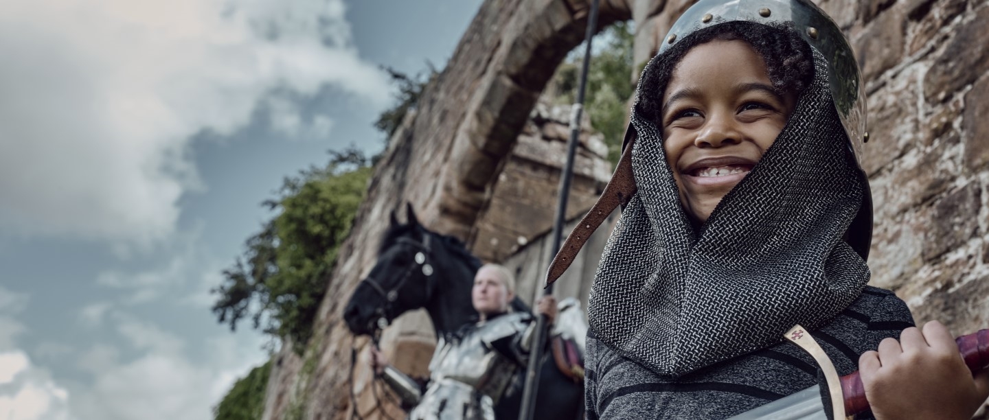 Photo of a child dressed as a knight and holding a sword